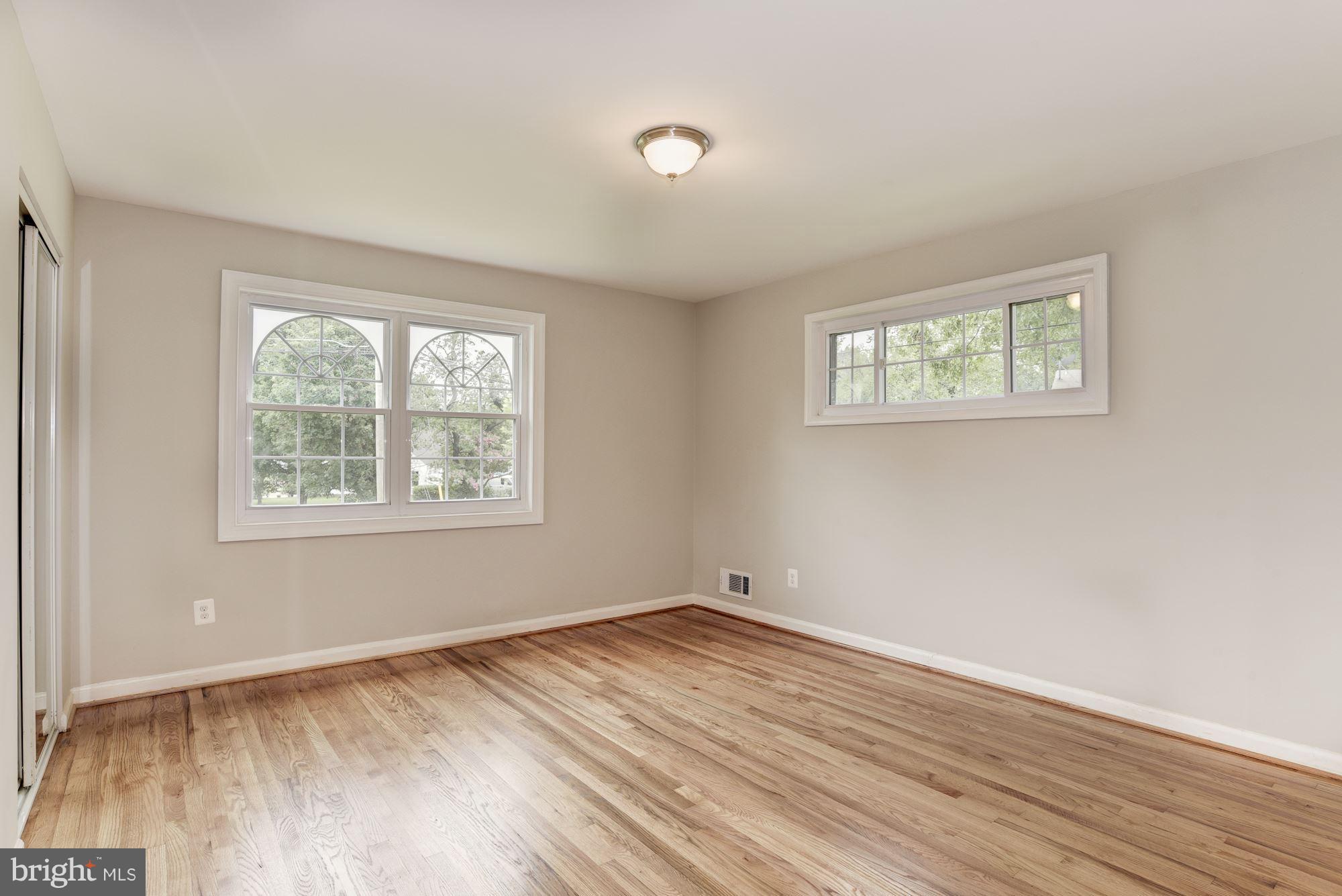 6916 Gilbert Street Springfield, VA 22150 - Photo 11 of 26 an empty room with wooden floor and windows