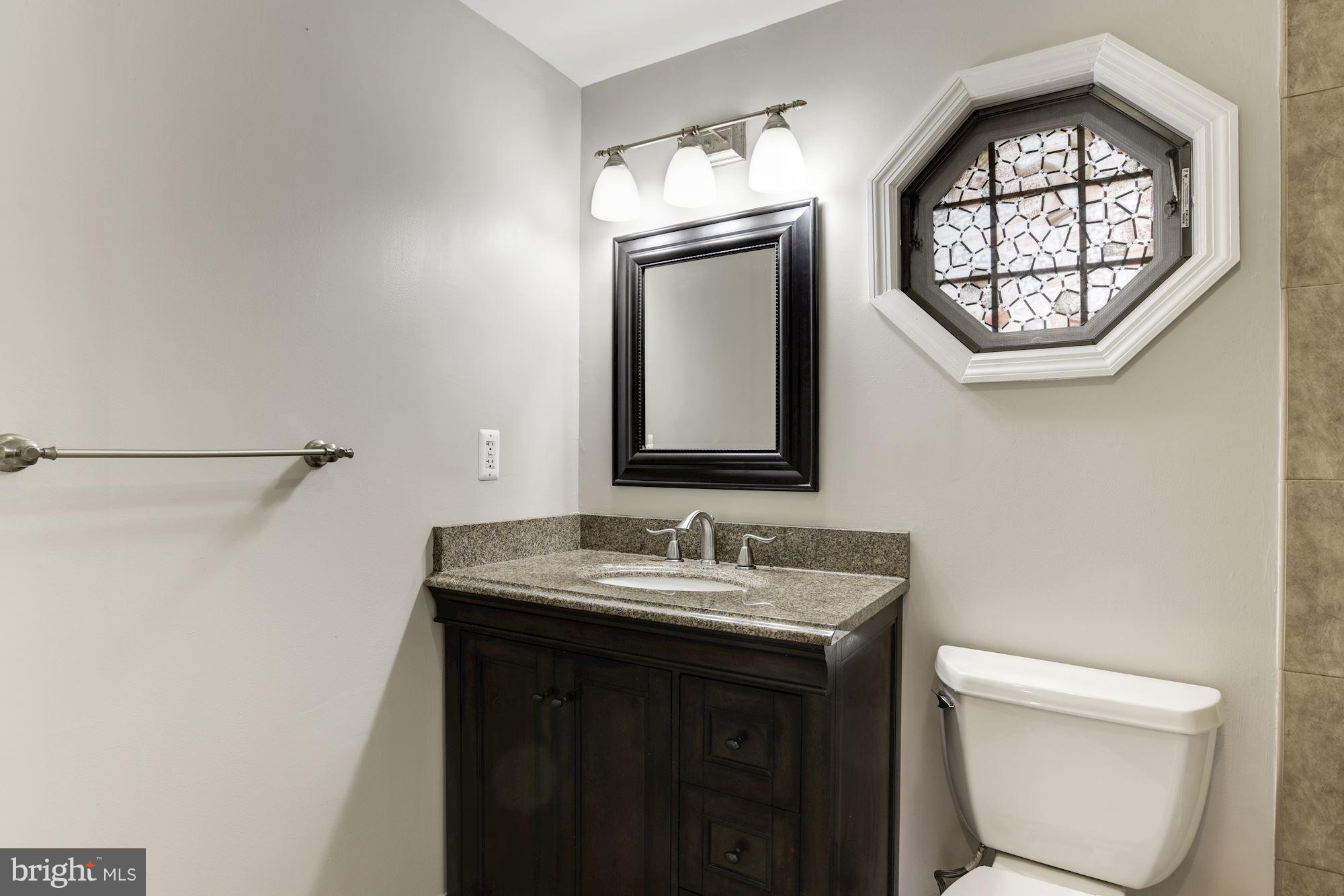 6916 Gilbert Street Springfield, VA 22150 - Photo 18 of 26 a bathroom with a toilet a sink and a mirror