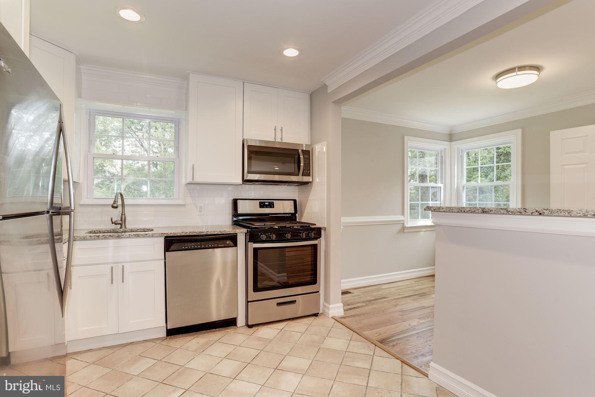 6916 Gilbert Street Springfield, VA 22150 - Photo 5 of 26 a kitchen with granite countertop a stove sink and microwave