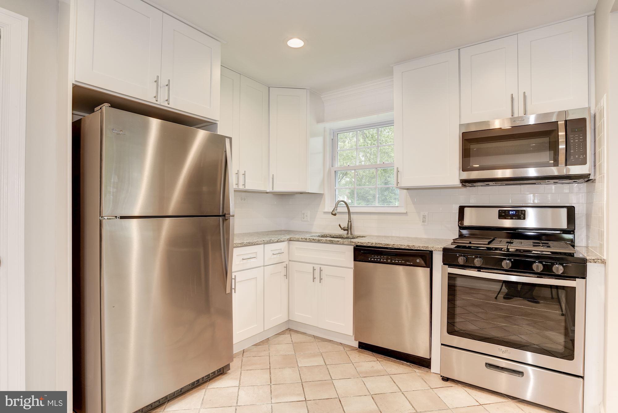 6916 Gilbert Street Springfield, VA 22150 - Photo 7 of 26 a kitchen with cabinets stainless steel appliances and a window