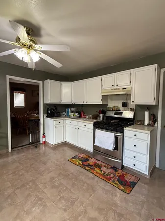 a kitchen with granite countertop a stove a sink and a refrigerator