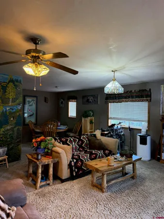 a living room with furniture a chandelier and a fireplace
