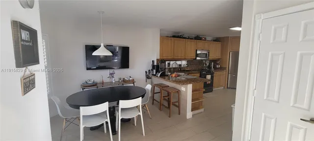 a kitchen with a table chairs refrigerator and microwave