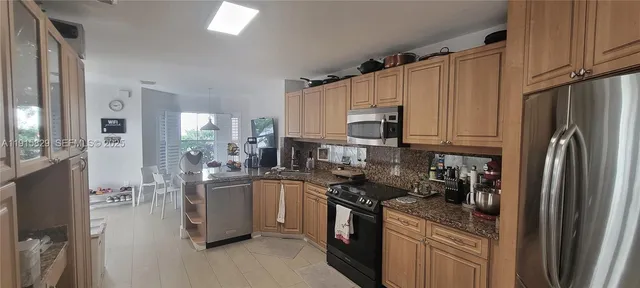 a kitchen with stainless steel appliances granite countertop a refrigerator stove and sink