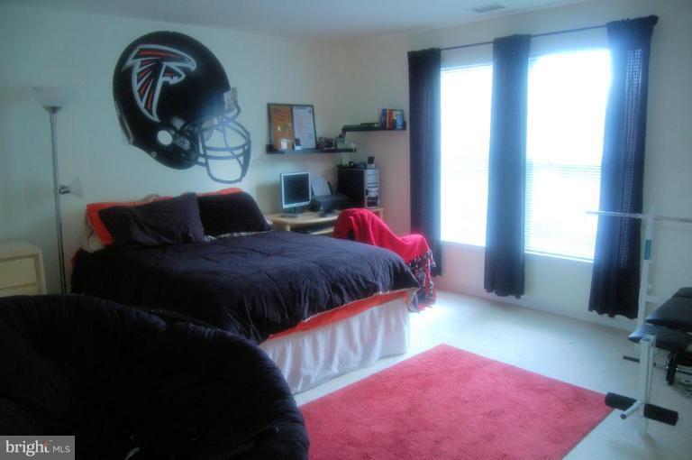 20600 Cornstalk Terrace, Unit 202 Ashburn, VA 20147 - Photo 7 of 12 a bedroom with a bed and a window