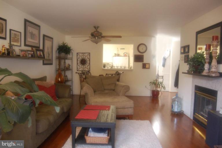 20600 Cornstalk Terrace, Unit 202 Ashburn, VA 20147 - Photo 9 of 12 a living room with furniture fireplace and wooden floor
