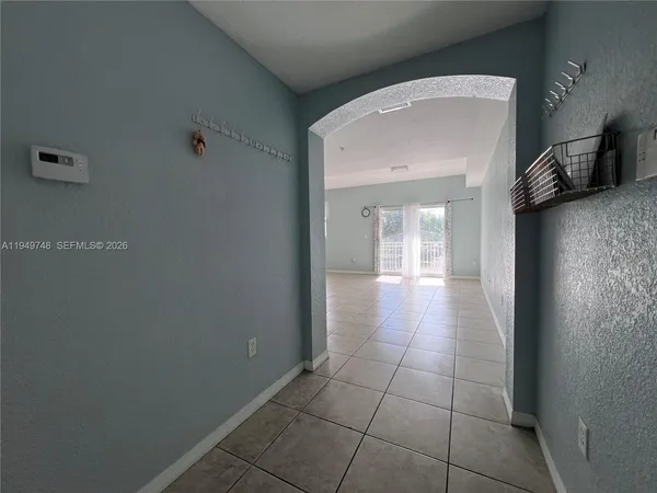a view of a hallway with wooden floor and a bathroom