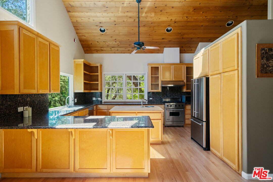 20912 Fontaine Road Topanga, CA 90290 - Photo 12 of 52 a kitchen with stainless steel appliances granite countertop a refrigerator a sink dishwasher a stove and white countertops with wooden floor