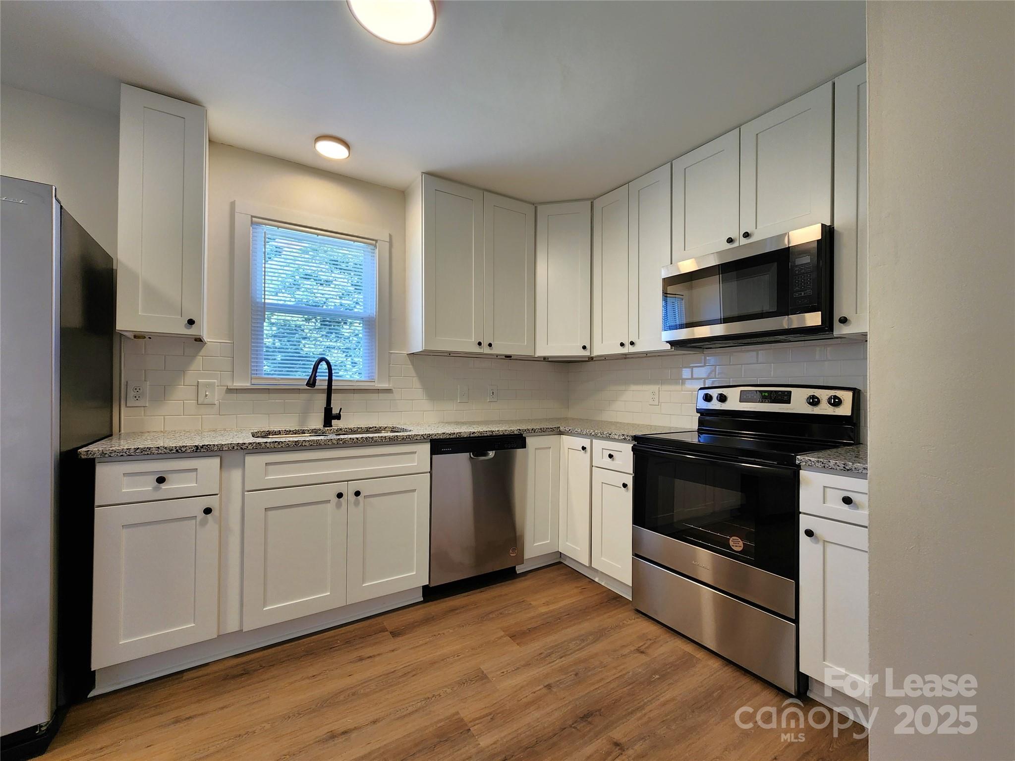 a kitchen with stainless steel appliances a stove a sink and a microwave