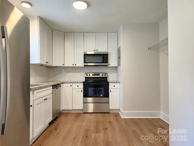 a kitchen with granite countertop a stove and a refrigerator