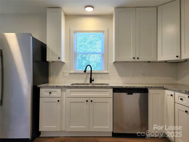a kitchen with white cabinets and a refrigerator