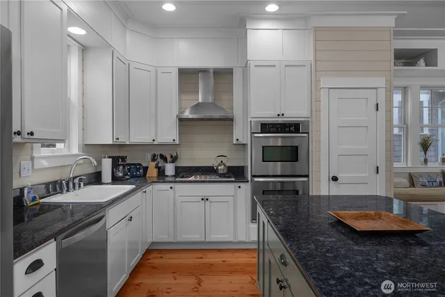 a kitchen with stainless steel appliances granite countertop a stove sink and cabinets