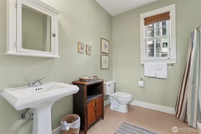 a bathroom with a sink toilet and a mirror