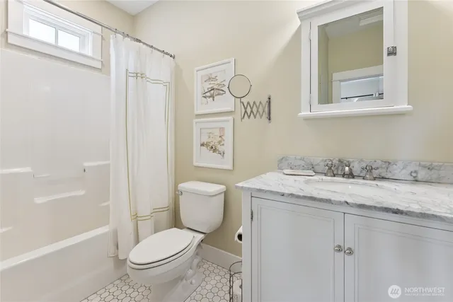 a bathroom with a granite countertop toilet sink and mirror