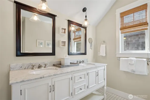a bathroom with double sink and a mirror