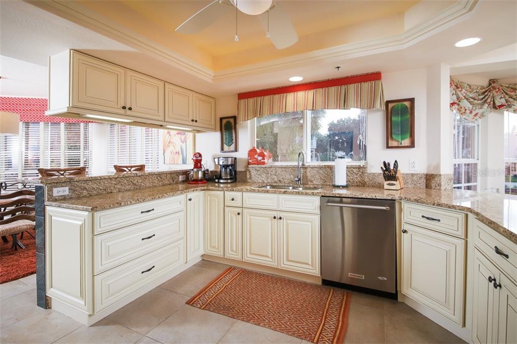 Updated kitchen features tray ceiling with accent lighting, granite & stainless appliances
