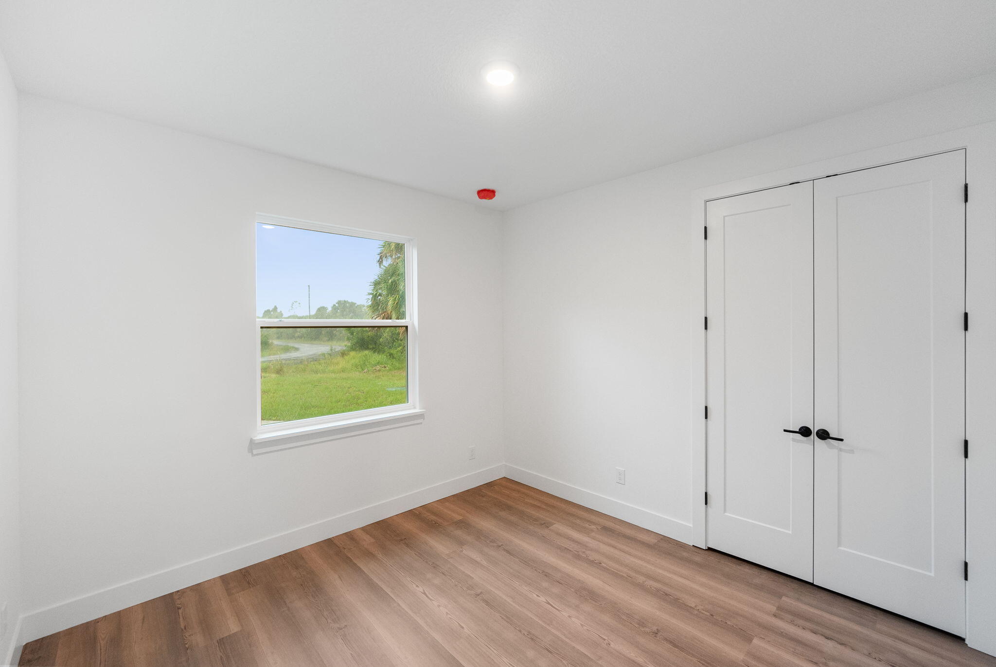 3113 Nighthawk Avenue Palm Bay, FL 32908 - Photo 21 of 33 a view of an empty room with wooden floor and a window