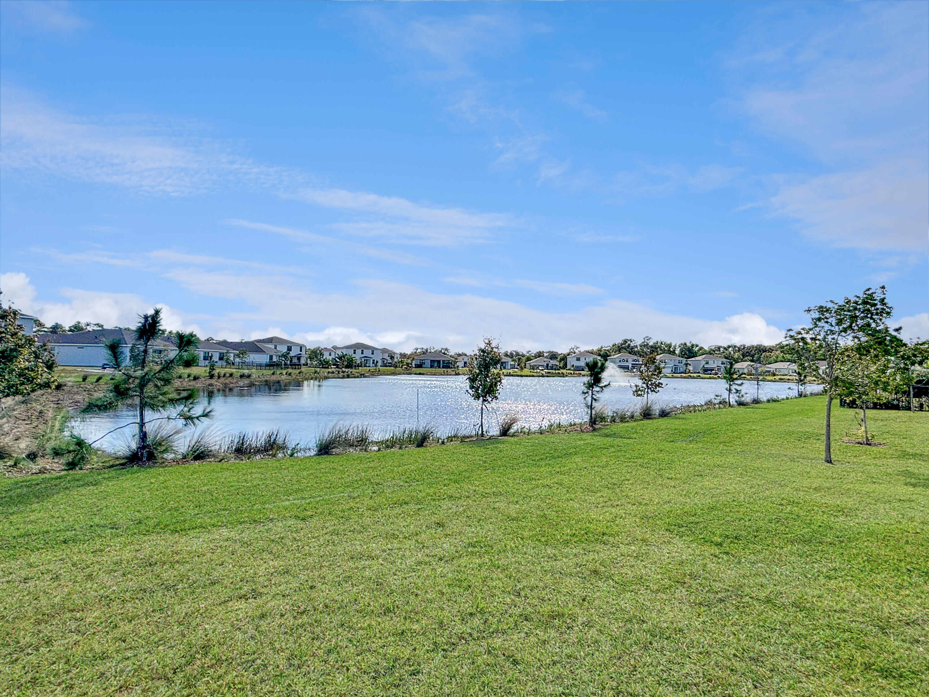 5989 Southeast Skyblue Circle Stuart, FL 34997 - Photo 32 of 37 a view of a lake with a yard