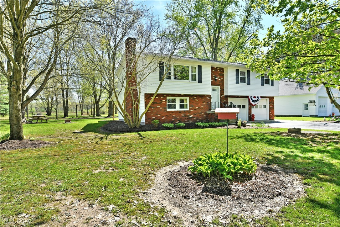 379 Housel Craft Road Bristolville, OH 44402 - Photo 3 of 50 Raised ranch with a garage, a front yard, a chimney, brick siding, and driveway
