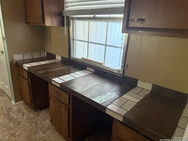 a kitchen with granite countertop a stove top oven microwave and cabinets