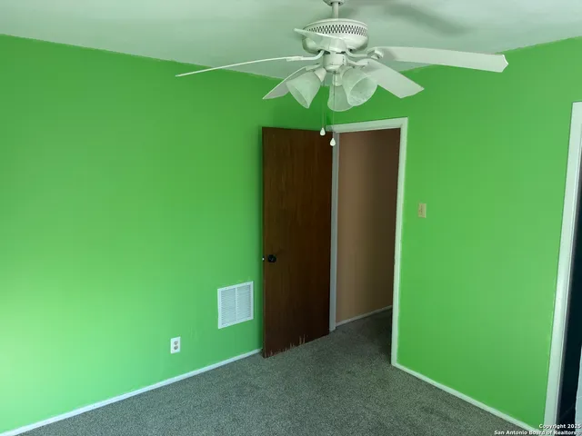 a view of an empty room with a window and a fan