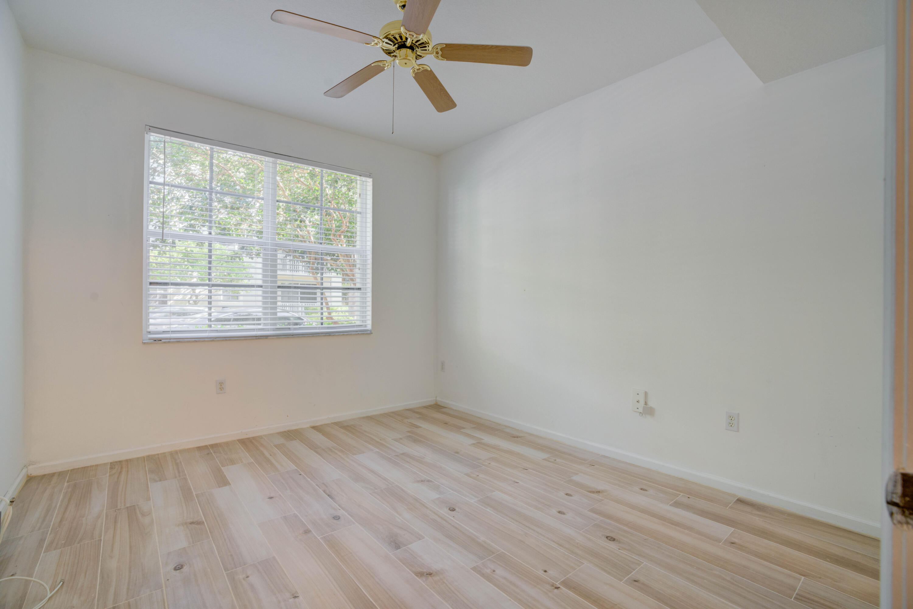 1136 Town Center Drive, Unit 11 Jupiter, FL 33458 - Photo 12 of 24 an empty room with wooden floor fan and windows