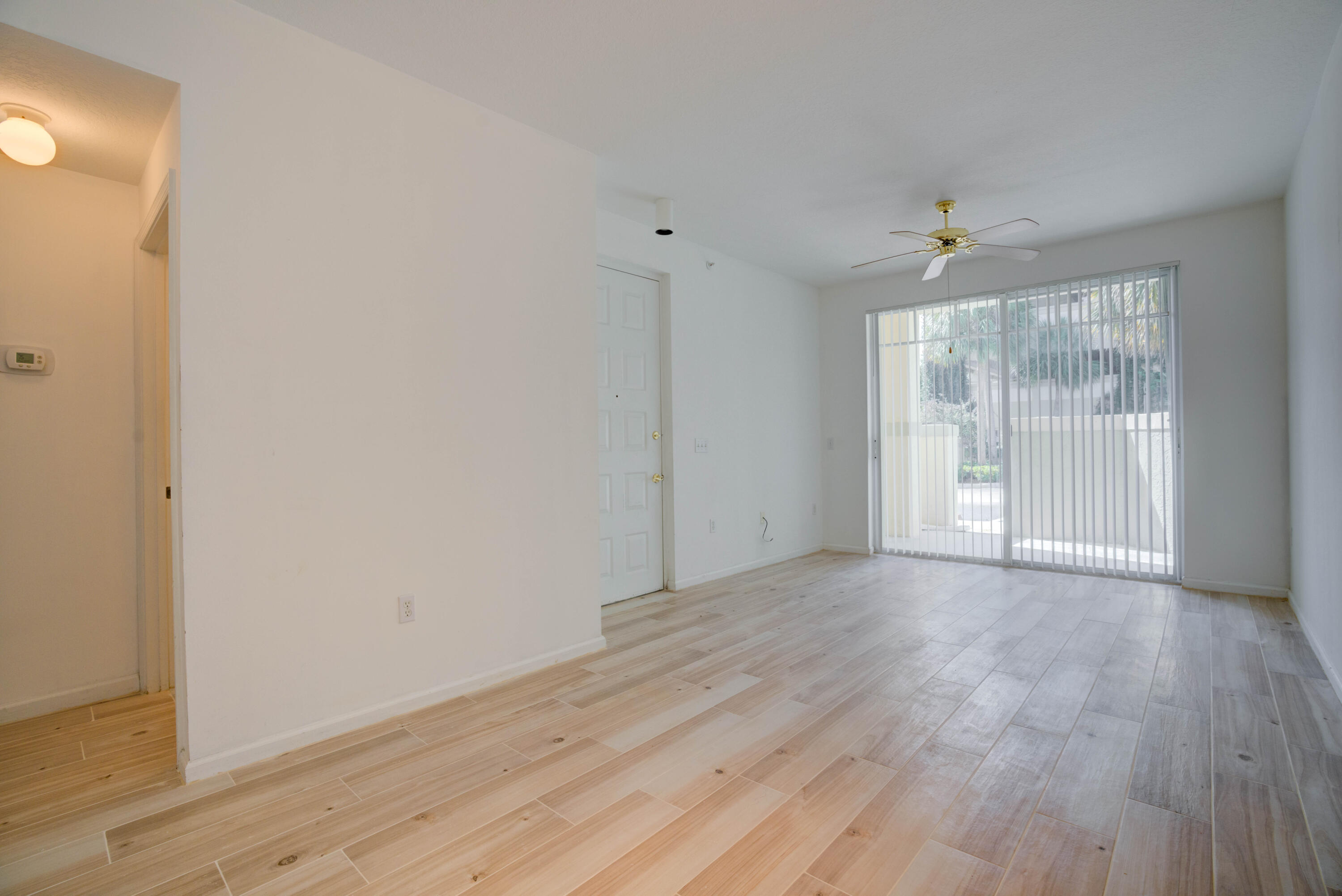 1136 Town Center Drive, Unit 11 Jupiter, FL 33458 - Photo 3 of 24 a view of an empty room with wooden floor and a window
