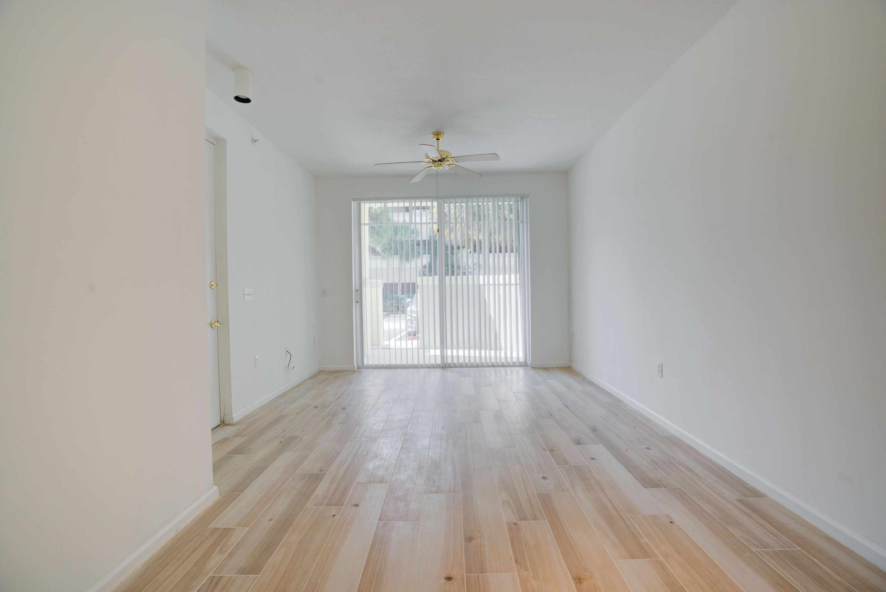 1136 Town Center Drive, Unit 11 Jupiter, FL 33458 - Photo 4 of 24 wooden floor in an empty room with a window