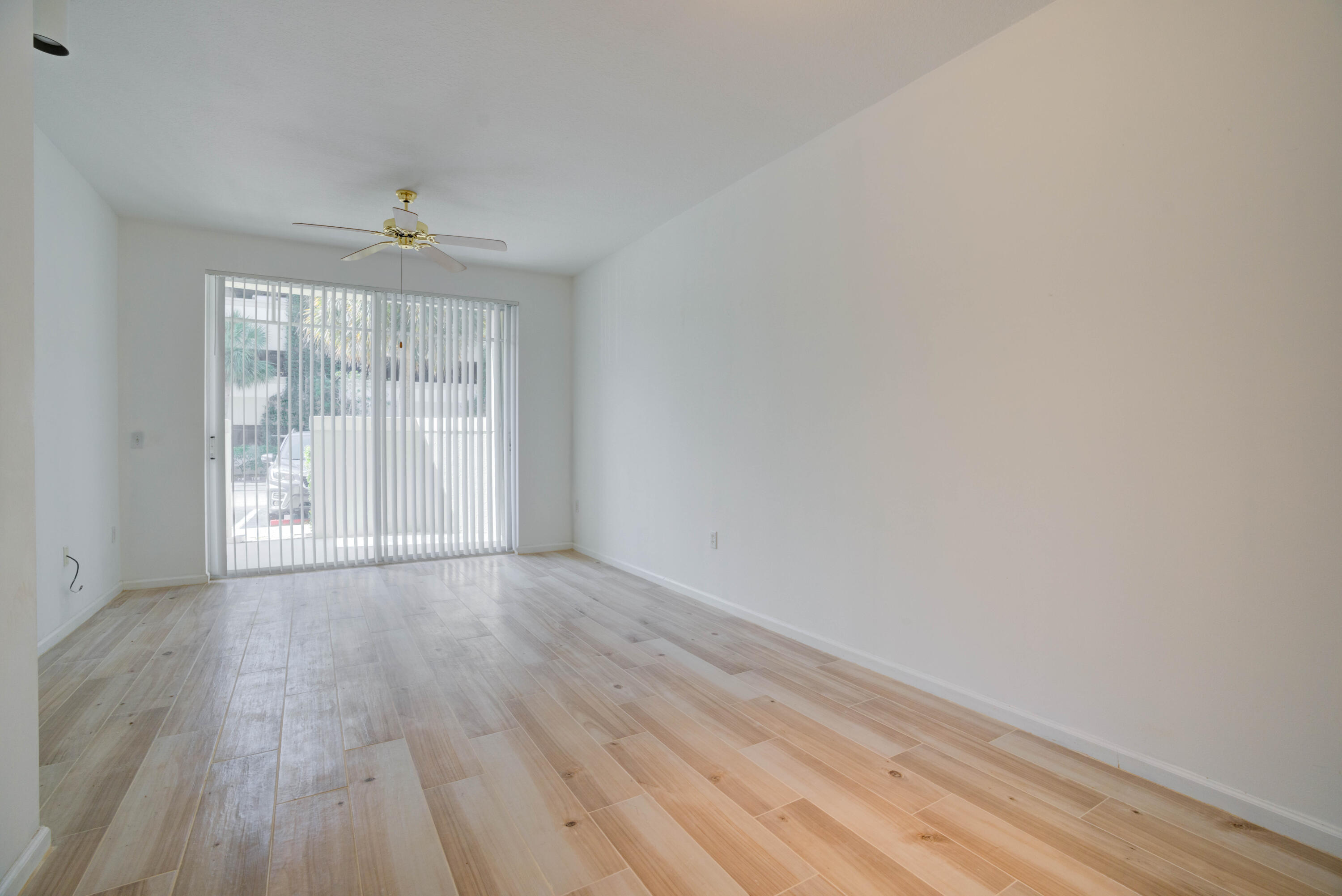 1136 Town Center Drive, Unit 11 Jupiter, FL 33458 - Photo 5 of 24 wooden floor in an empty room with a window