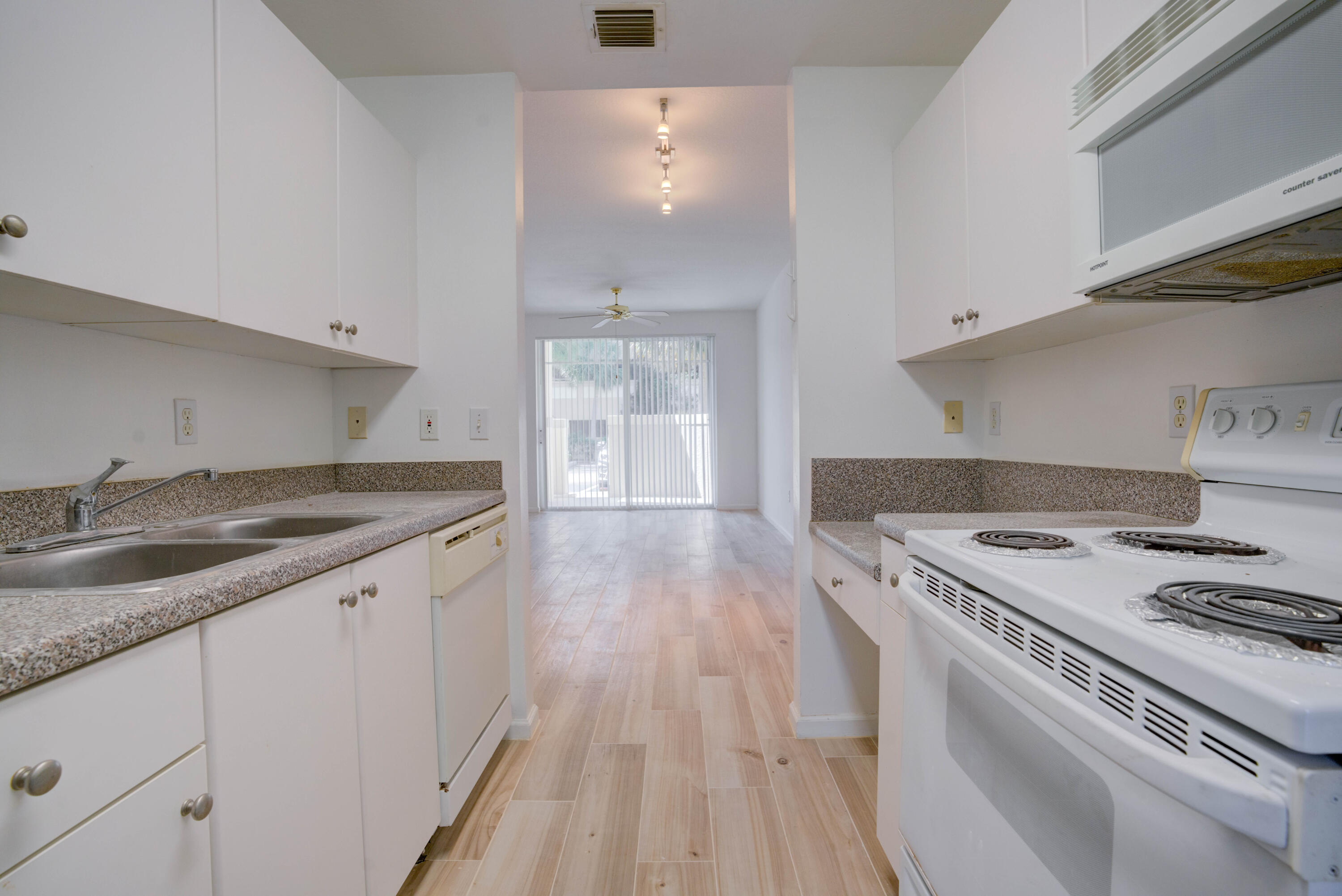 1136 Town Center Drive, Unit 11 Jupiter, FL 33458 - Photo 9 of 24 a kitchen that has a sink a stove and wooden floor