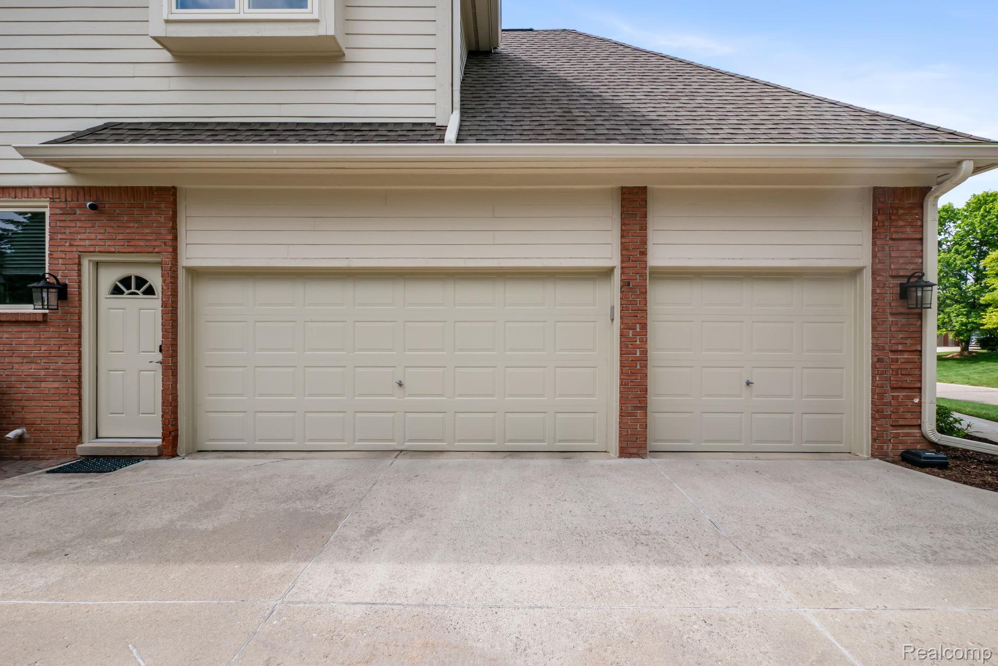 1902 Grayslake Drive Rochester, MI 48306 - Photo 61 of 76 Two-car garage with panel-style doors, complemented by brick and siding exterior finishes