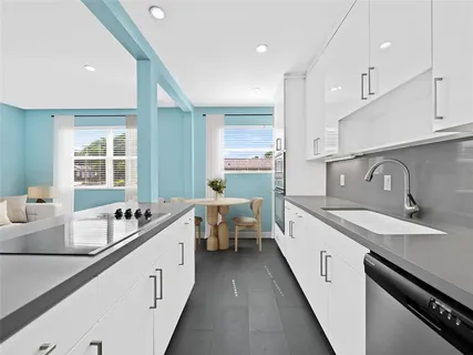 a large white kitchen with a large window