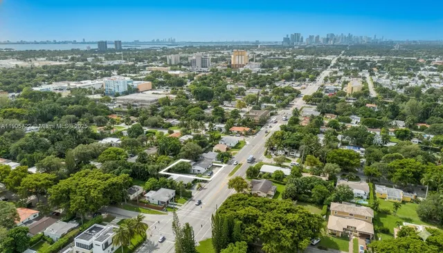 an aerial view of residential houses with outdoor space and trees
