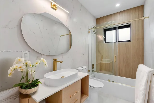 a bathroom with a granite countertop sink mirror and toilet
