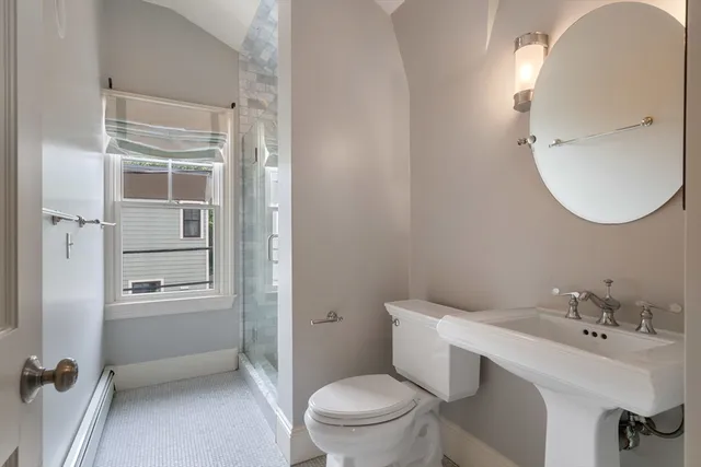 a bathroom with a sink a toilet and shower