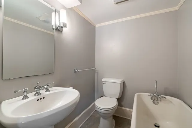a bathroom with a toilet a sink and mirror