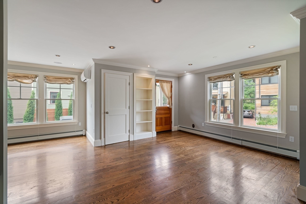 23 Bellis Circle Cambridge, MA 02140 - Photo 9 of 24 an empty room with wooden floor and windows
