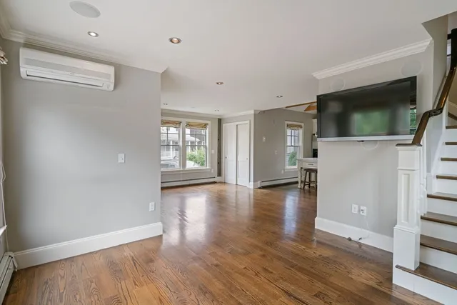 a view of a livingroom with wooden floor and a flat screen tv
