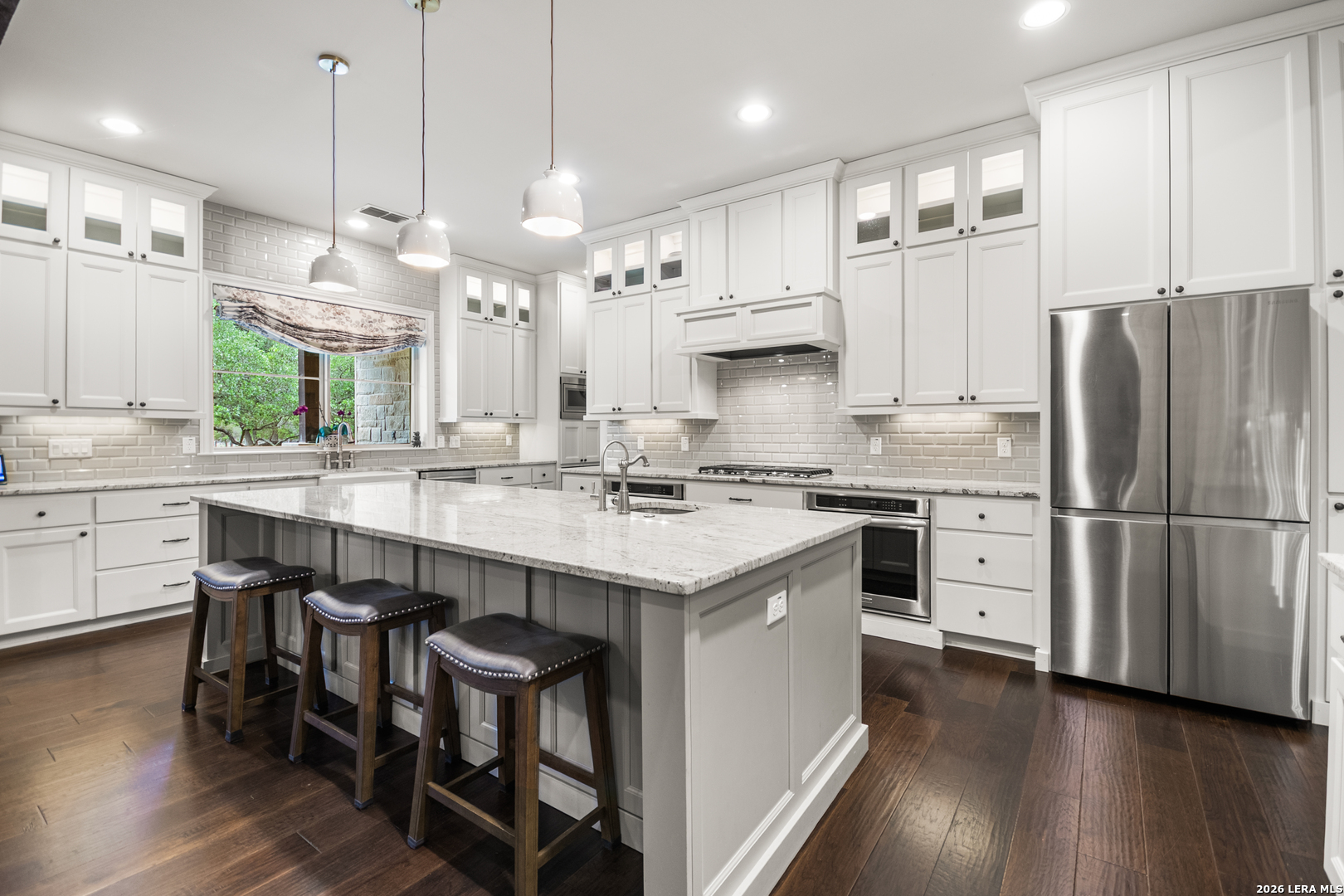 55 Brook Ridge Boerne, TX 78015 - Photo 6 of 59 a kitchen with stainless steel appliances granite countertop a table chairs stove a sink dishwasher a refrigerator and a dining table with wooden floor