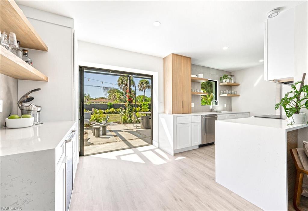 4608 Normandy Drive Naples, FL 34112 - Photo 15 of 49 a kitchen with a wooden floor and a large window