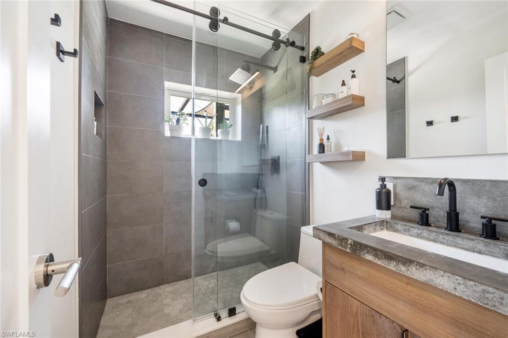 4608 Normandy Drive Naples, FL 34112 - Photo 18 of 49 a bathroom with a granite countertop sink toilet and shower