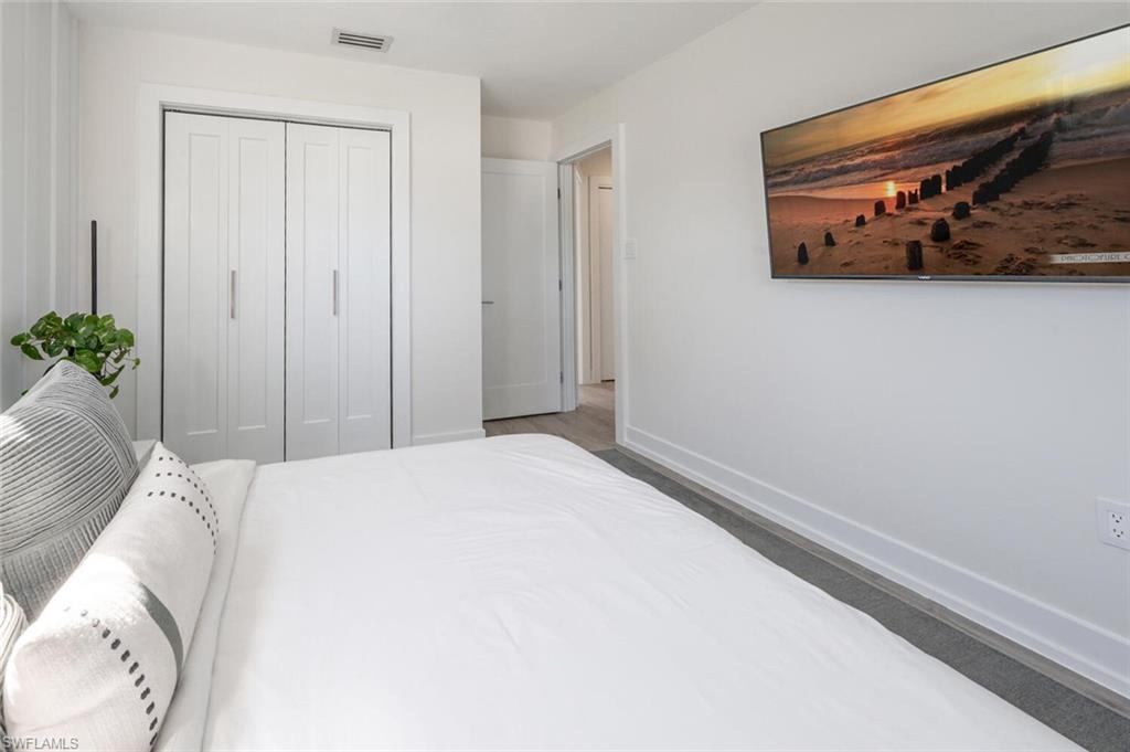 4608 Normandy Drive Naples, FL 34112 - Photo 23 of 49 a bedroom with a bed and a painting on the wall