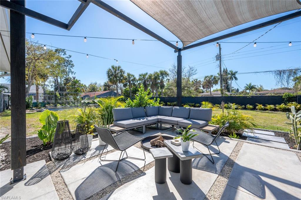 4608 Normandy Drive Naples, FL 34112 - Photo 28 of 49 a view of a patio with a dining table and chairs potted plants with floor to ceiling window and potted plants