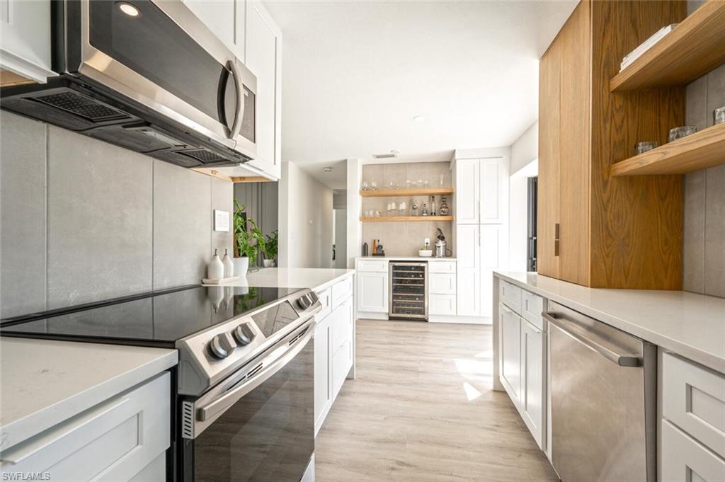 4608 Normandy Drive Naples, FL 34112 - Photo 8 of 49 a kitchen with stainless steel appliances granite countertop a stove and a refrigerator