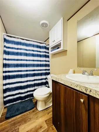 a bathroom with a granite countertop sink toilet and a mirror