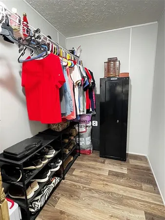 a view of walk in closet with clothes and shoes
