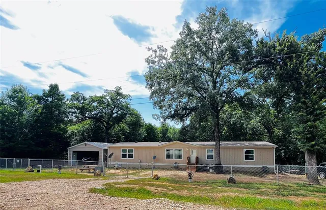 a view of house with swimming pool and a yard
