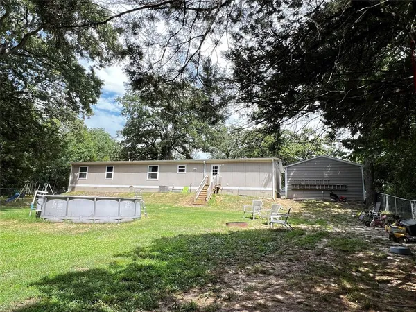 a view of a backyard with a garden and trees