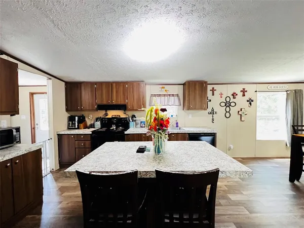 a kitchen with stainless steel appliances wooden floor dining table and chairs