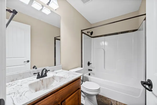 a bathroom with a granite countertop sink toilet and shower